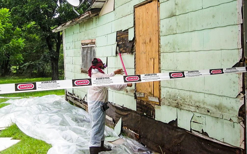Worker in protective equipment at an asbestos abatement project site