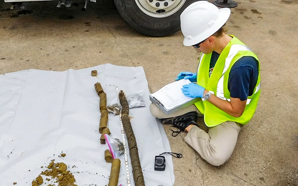Environmental field professional documenting soil samples during a site investigation